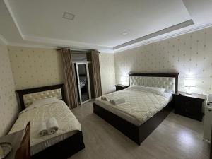 撒马尔罕撒马尔罕拉蒂夫酒店的一间卧室配有两张床和镜子