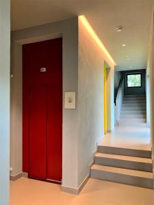 阿夏戈若兹尔酒店的走廊上设有红色的门,设有楼梯