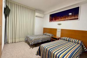 贝尼多姆拉奥罗扎宾馆的一间酒店客房,设有两张床和电视