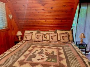加特林堡Buckberry Creek Chalet的一间卧室配有一张大床和木制床头板