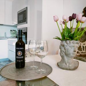 卡斯蒂利翁切洛Suite Eleven的桌子上放有一瓶葡萄酒和两杯酒