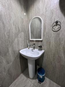 利雅德Kada Suites的浴室设有白色水槽和镜子
