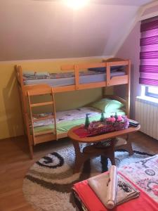 新瓦罗什Apartmani NINA Zlatar的客房设有两张双层床和一张桌子。