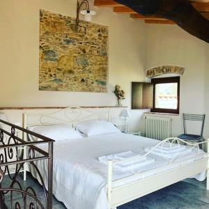 卡斯泰尔诺沃马格拉Casa Dell'Angelo的卧室配有白色的床和石墙