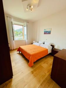 赫瓦尔路克雷西亚公寓的一间卧室配有一张带橙色毯子的大床