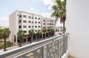 杰迪代Appartement 3 CHAMBRES ensoleillé à 5 min de la plage El Jadida的阳台享有街道和建筑的景致。
