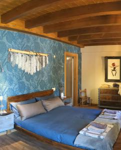 伊萨尔苏XANDUA Etxea - Selva de Irati -的卧室内的一张床铺,配有蓝色壁纸