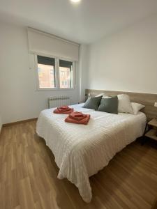 萨莫拉Apartamento NyA Zamora的白色卧室配有一张大床和两条毛巾
