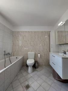 凯法利尼亚岛Giannata House的浴室配有卫生间、浴缸和水槽。