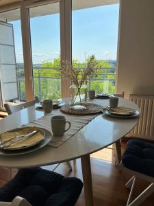 格丁尼亚Prime Home SŁONECZNY的餐桌上放有盘子和杯子