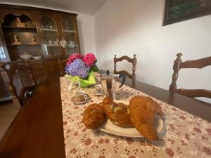 皮索涅Casa vacanze il pettirosso.的一张桌子,上面放着一盘羊角面包和鲜花