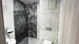 DoğubayazıtATLIHAN PLUS HOTEL的黑白浴室设有淋浴和卫生间