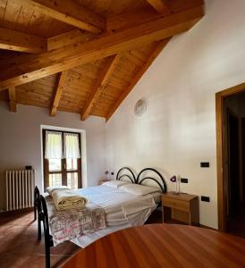 EnguisoAppartamenti Casa Miravalle的一间卧室设有一张床和木制天花板