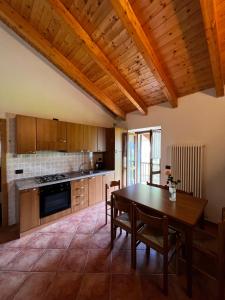 EnguisoAppartamenti Casa Miravalle的厨房设有木桌和木制天花板。