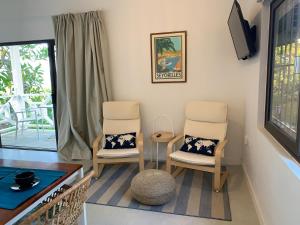 马埃岛Naturalis - Oceanview Residences的客厅配有两把椅子和一张桌子