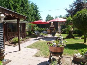 PottumFerienhaus Tanneneck的花园配有桌椅和红色遮阳伞