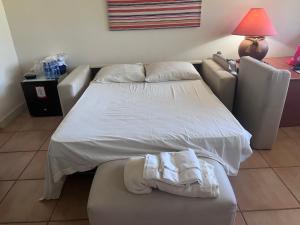 查梅Aurora Luxury Suite con acceso a la playa的卧室配有白色的床和沙发