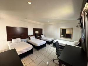 墨西卡利Hotel Don Quijote的酒店客房配有两张床和一张书桌