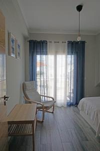 ParchalCasa Gaio's的一间卧室配有椅子、一张床和一张桌子