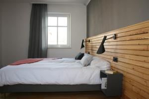 萨克森自由州诺伊斯塔滕FEWO am Markt的一间卧室配有一张大床和木制床头板