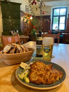 赫亨基尔兴-西格尔茨布伦Gasthaus Franz Inselkammer的一张桌子,上面放着一盘食物和一篮面包