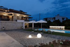 阿尔戈斯Villa Ero的夜间带游泳池的别墅