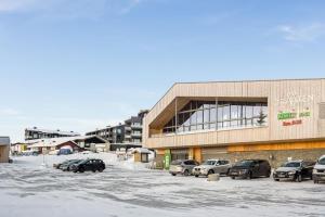 斯朱森Leilighet med panoramautsikt Sjusjøen Innendørs parkering的停车场,停车场停在大楼前