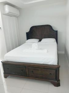 波特莫尔Impeccable 2-BR Apartment-Ornella Villa at Bayfront Villa的一张带木制框架和白色床单的床