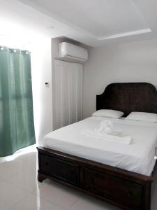 波特莫尔Impeccable 2-BR Apartment-Ornella Villa at Bayfront Villa的一间卧室配有一张大床和木制床头板