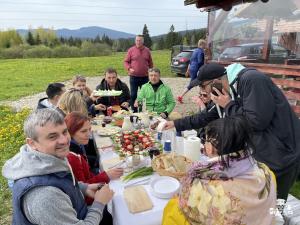 BorzontTransylvania Apartments的一群坐在桌子旁吃食物的人
