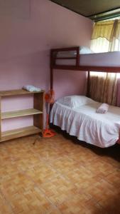 GambaLodging Adventure La Gamba的一间卧室配有双层床,铺有木地板