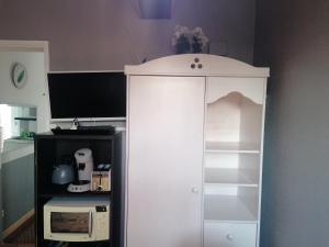 弗兰奎维尔-圣皮尔Charmant Appartement 10mn Rouen的厨房内的白色橱柜,配有微波炉