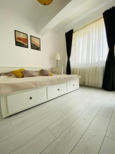布加勒斯特Orhideea Central Apartments的白色的卧室设有一张大床和一个窗户