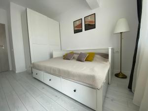 布加勒斯特Orhideea Central Apartments的白色卧室配有床和灯