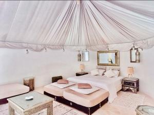 马拉喀什Les jardins d isis的一间卧室设有两张床和天篷