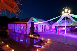 马拉喀什Les jardins d isis的夜晚亮着紫色和绿灯的帐篷