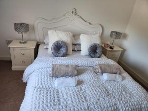 斯旺西Rothwell的一张带枕头和毛巾的白色床