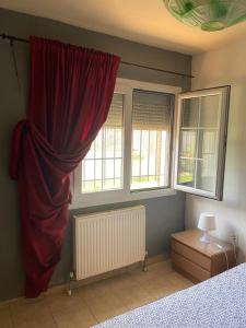 尼亚米卡尼奥纳George Garden的一间卧室设有红色窗帘和2扇窗户