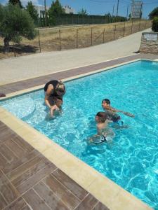 耶拉基尼Delmare Olive beach house II的游泳池里的一名妇女和两名儿童