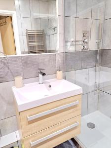 伦敦Tottenham Spur Hideaway的浴室配有白色水槽和淋浴。