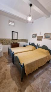 姆迪纳Palazzo del Prelato的配有两张床铺的客房,墙上配有电视