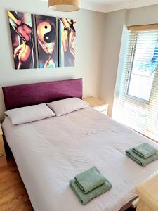 伦敦Tottenham Spur Hideaway的一间卧室配有一张床,上面有两条毛巾