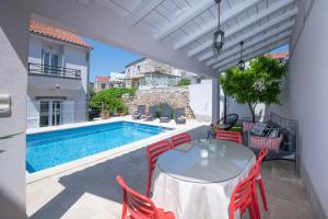 维斯Villa Mediterana的一个带桌椅的庭院和一个游泳池