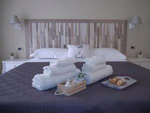 格拉维纳迪卡塔尼亚Viaggio in Sicilia B&B的床上的一大堆毛巾和面包