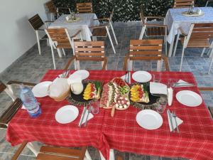 CupşeniAgropensiunea Pe Poderei的红色桌布上带食物盘的桌子