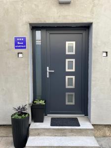 温科夫齐Apartman Beli的两棵盆栽植物的建筑上的一扇蓝色门