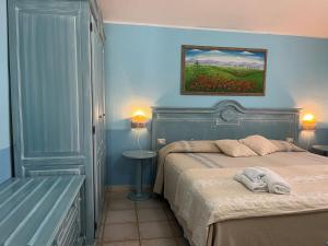 巴里萨尔多拜亚塞酒店的卧室配有一张床,墙上挂有绘画作品