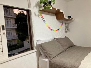 萨尔瓦多Suíte em Luna & Line的一间卧室配有一张床和一个植物窗户