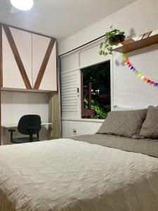 萨尔瓦多Suíte em Luna & Line的一间卧室配有一张床、一张书桌和一个窗户。
