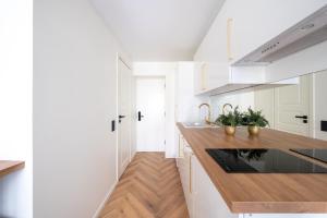 塔林Tallinn Oasis Studios by RevalHome的厨房配有白色橱柜和木制台面